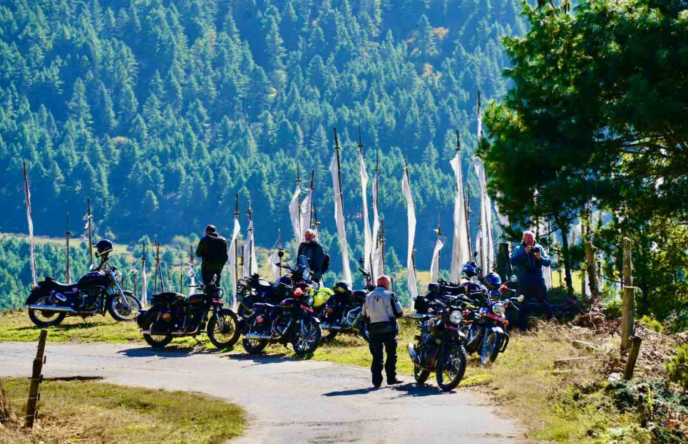 Rider on Royal Enfield crossing Chele La Pass during Bhutan motorcycle tour