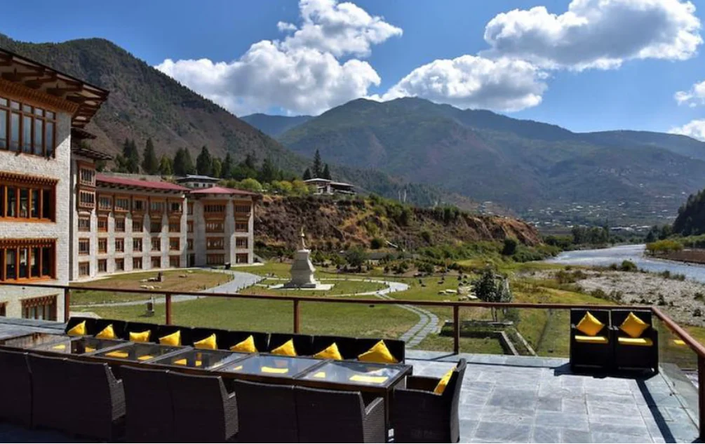 Bhutan hotels exterior at sunrise with snow-capped Himalayan peaks — bhutan hotels traditional architecture